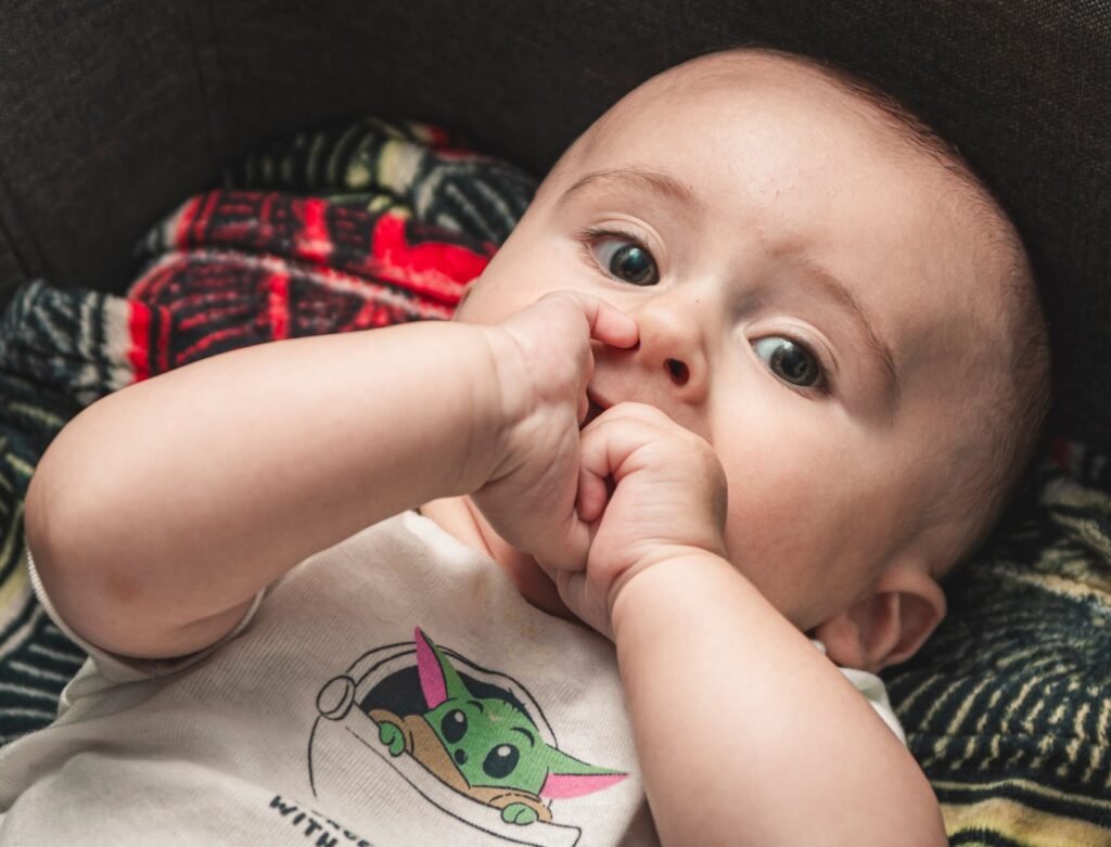 A baby happily chewing on a safe teething ring for relief