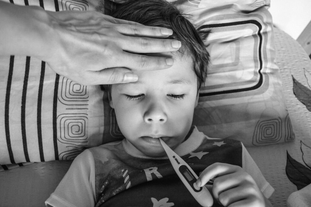 A child using a thermometer to check for fever