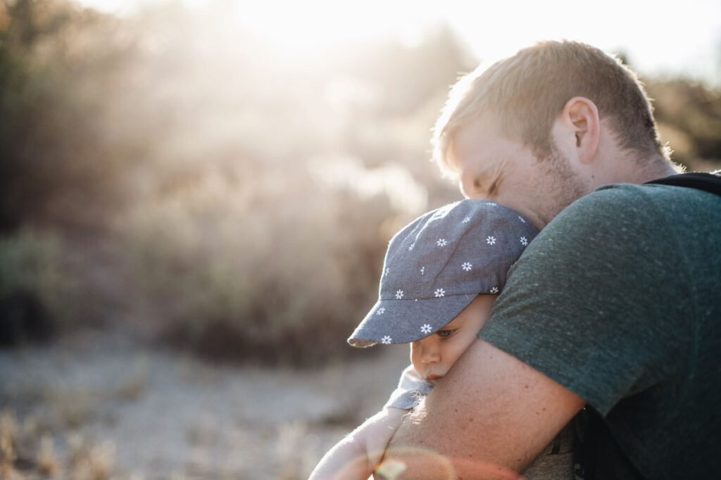 A father cradling his baby son in his arms
