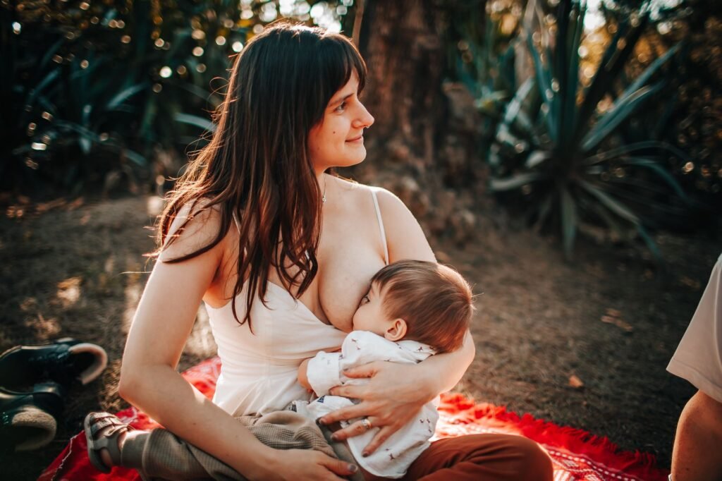 A mother breastfeeding her newborn in a calm, cozy setting