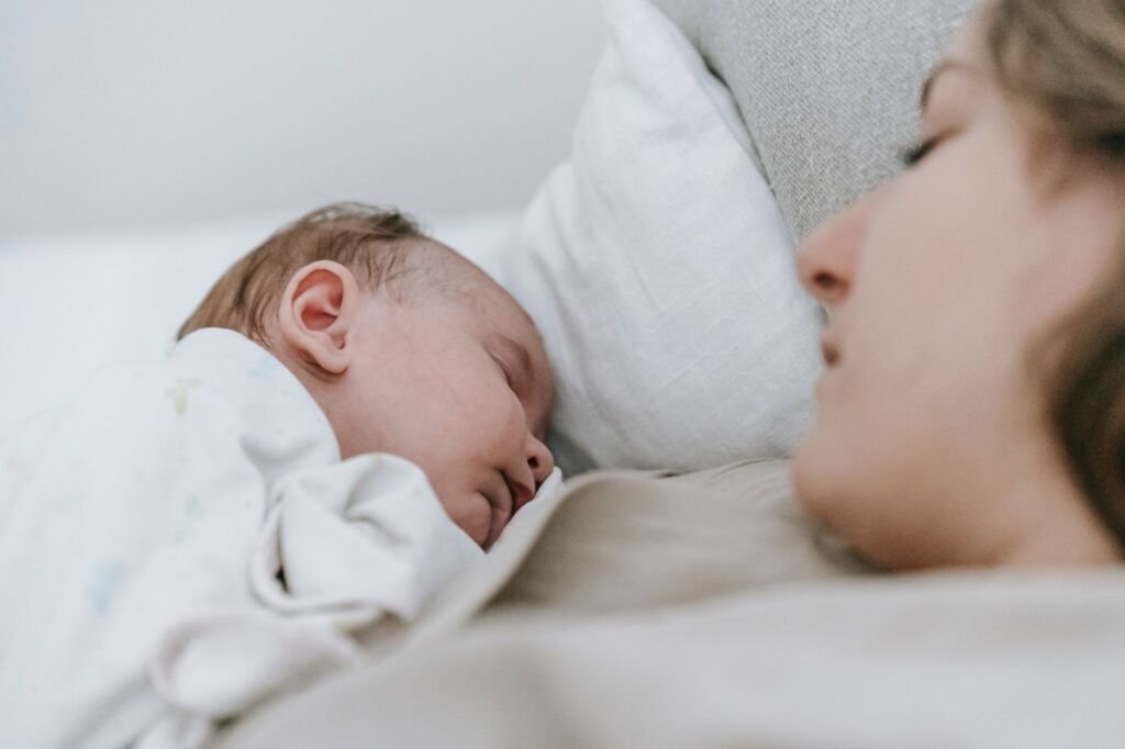 A mother gently comforting her baby as they prepare for sleep