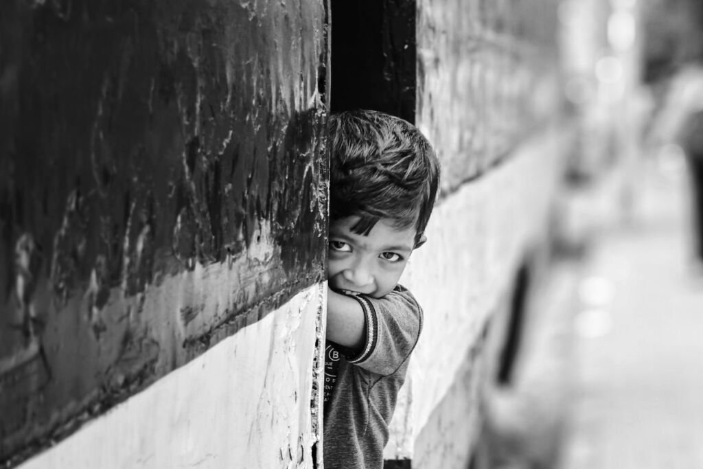 A shy child observing other kids playing at a playground