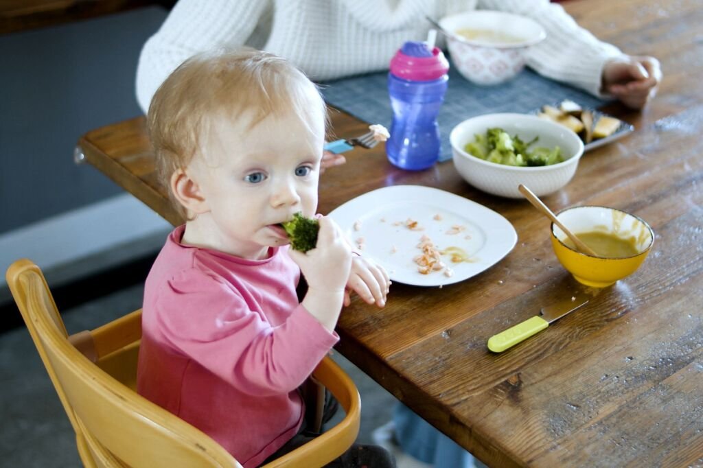 A toddler curiously exploring vegetables, encouraging healthy eating habits