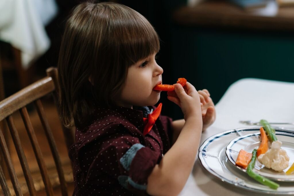 A toddler eagerly tasting soft vegetables, experiencing new textures
