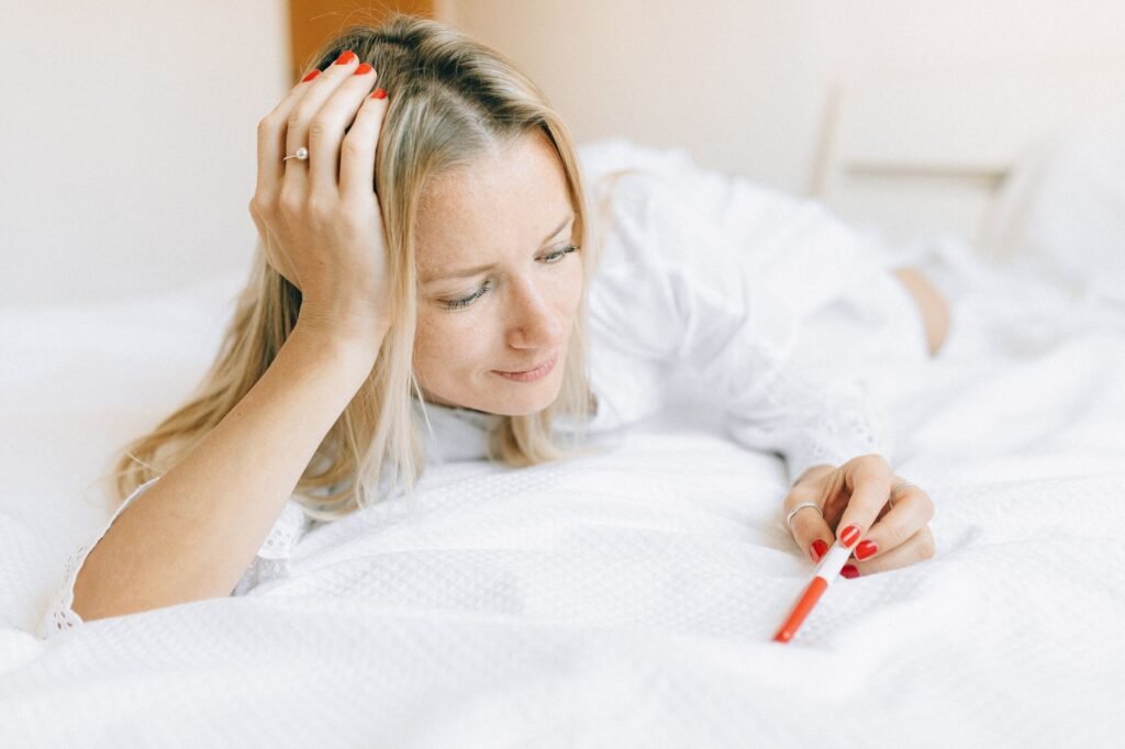 A woman looking at a pregnancy test with anticipation