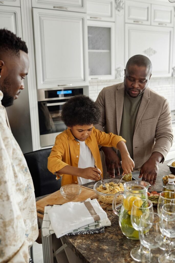 Father and son cooking together in the kitchen, enjoying quality time preparing a meal.