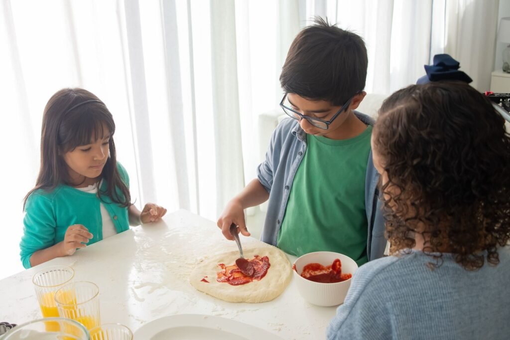 Children adding toppings to homemade pizzas