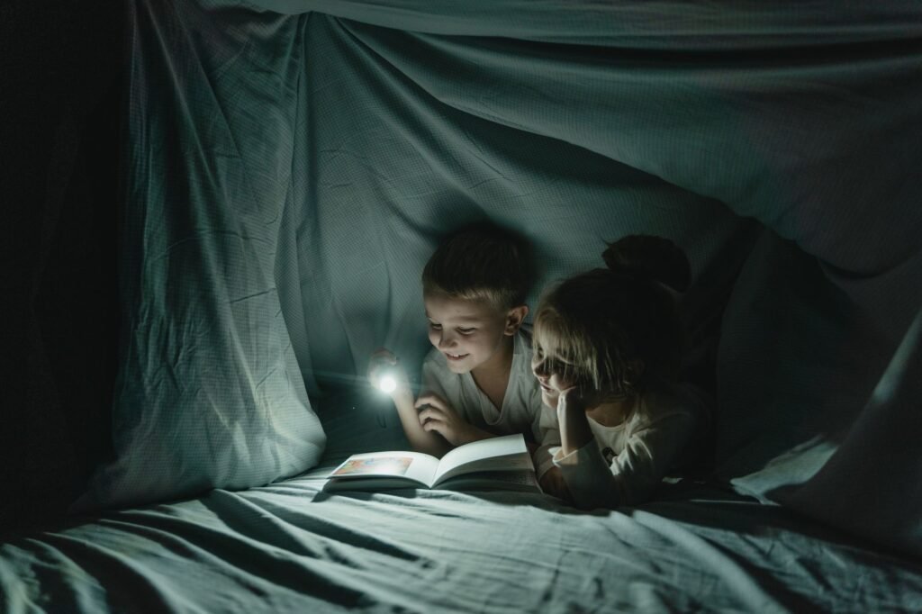 Children building a cozy blanket fort indoors