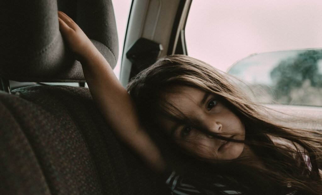 Children happily passing time in the back seat on a trip