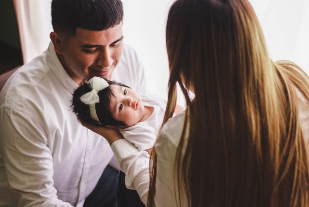 Parents smiling down at their newborn daughter