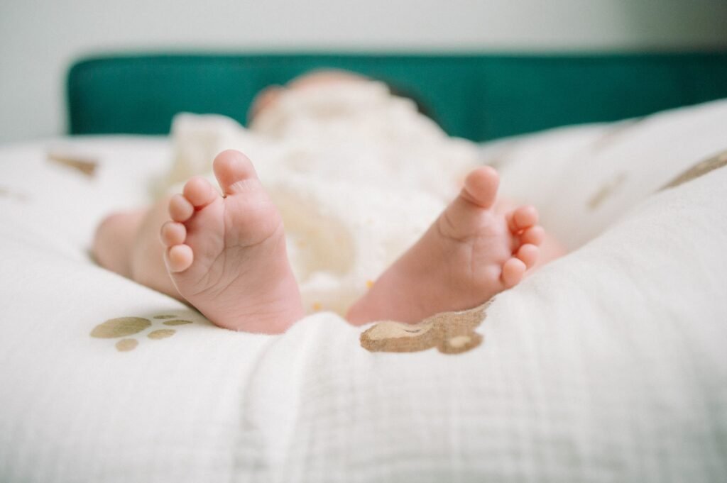 Tiny newborn feet peeking out from a soft blanket