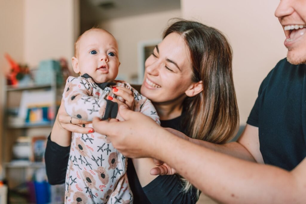 Two parents gently holding their newborn baby together