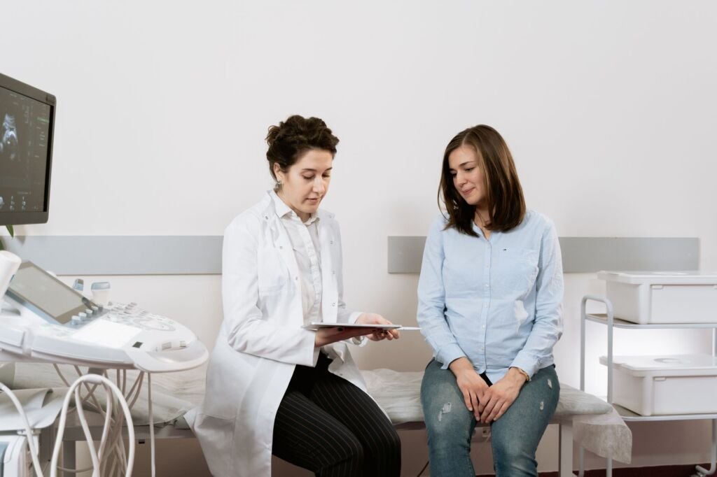 A doctor performing a physical exam on a pregnant woman to check her health and the baby's development