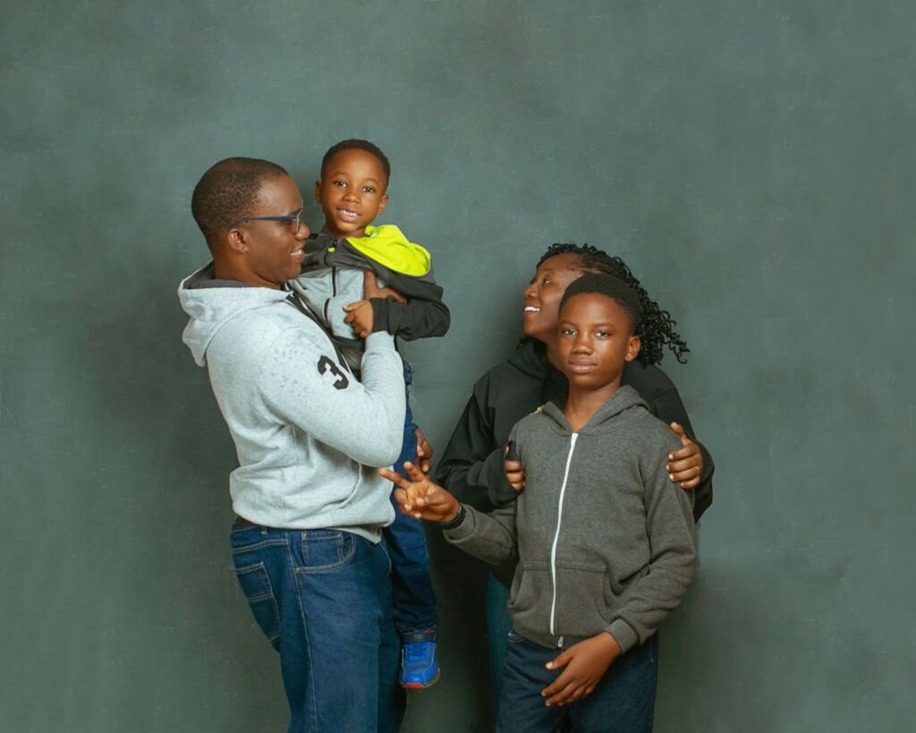 A joyful African family of four posing together in casual clothing, enjoying a moment of togetherness