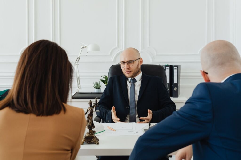 A professional business meeting with a lawyer and clients in a modern office setting