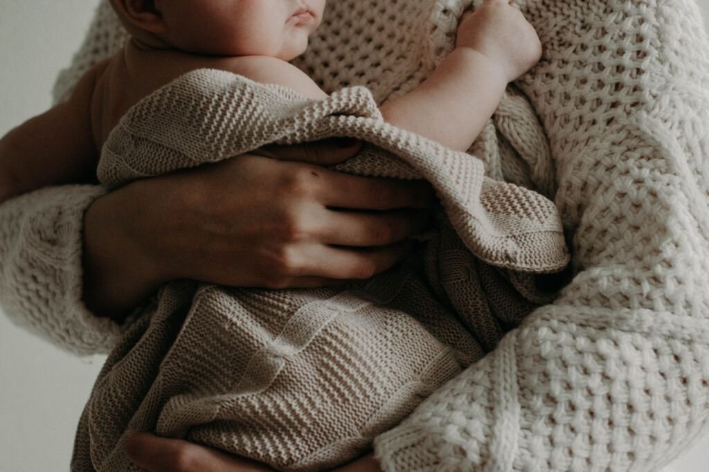 A tender moment of a mother holding her baby wrapped in a blanket