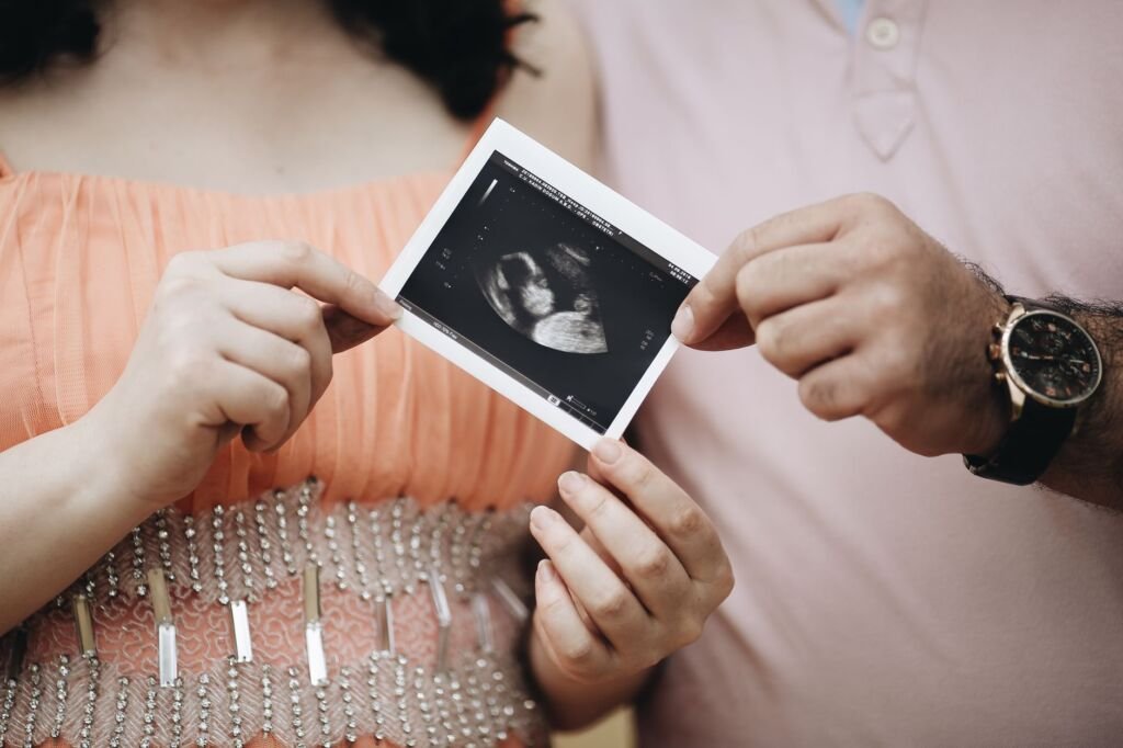 An expecting mother consulting with her healthcare provider during a prenatal checkup