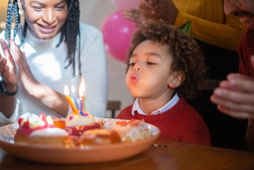 Kids excitedly blowing out candles on a homemade cake